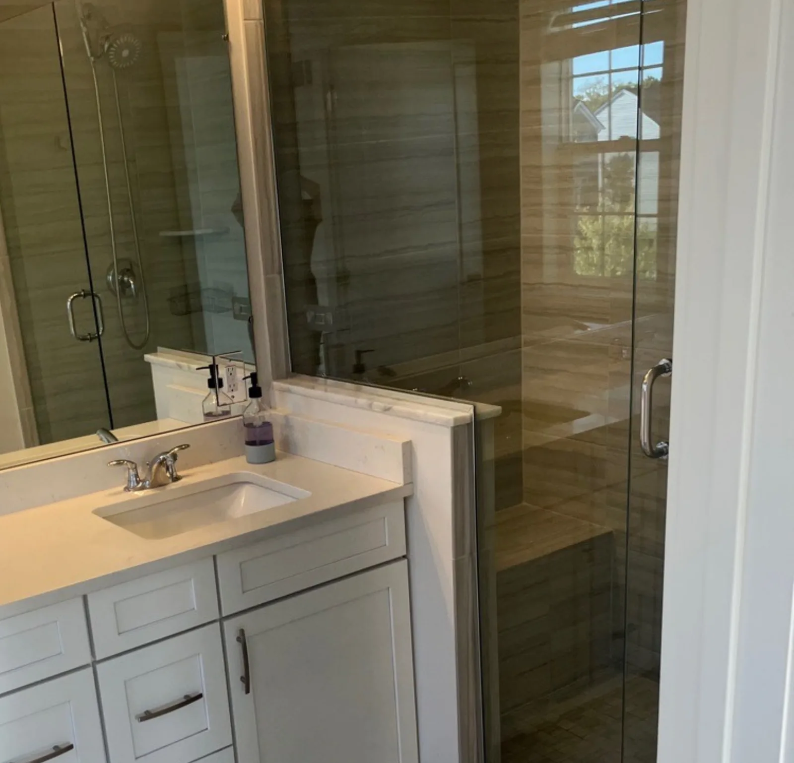 Deep-cleaned bathroom with marble vanity and glass-enclosed tiled shower — Verde Luxe Cleaning