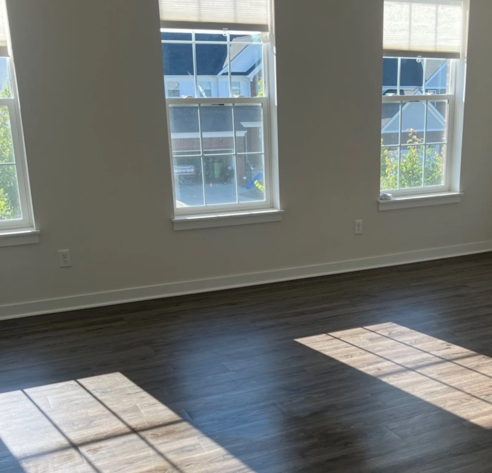 Empty room cleaned move-out ready with bright windows and carpet — Verde Luxe Cleaning