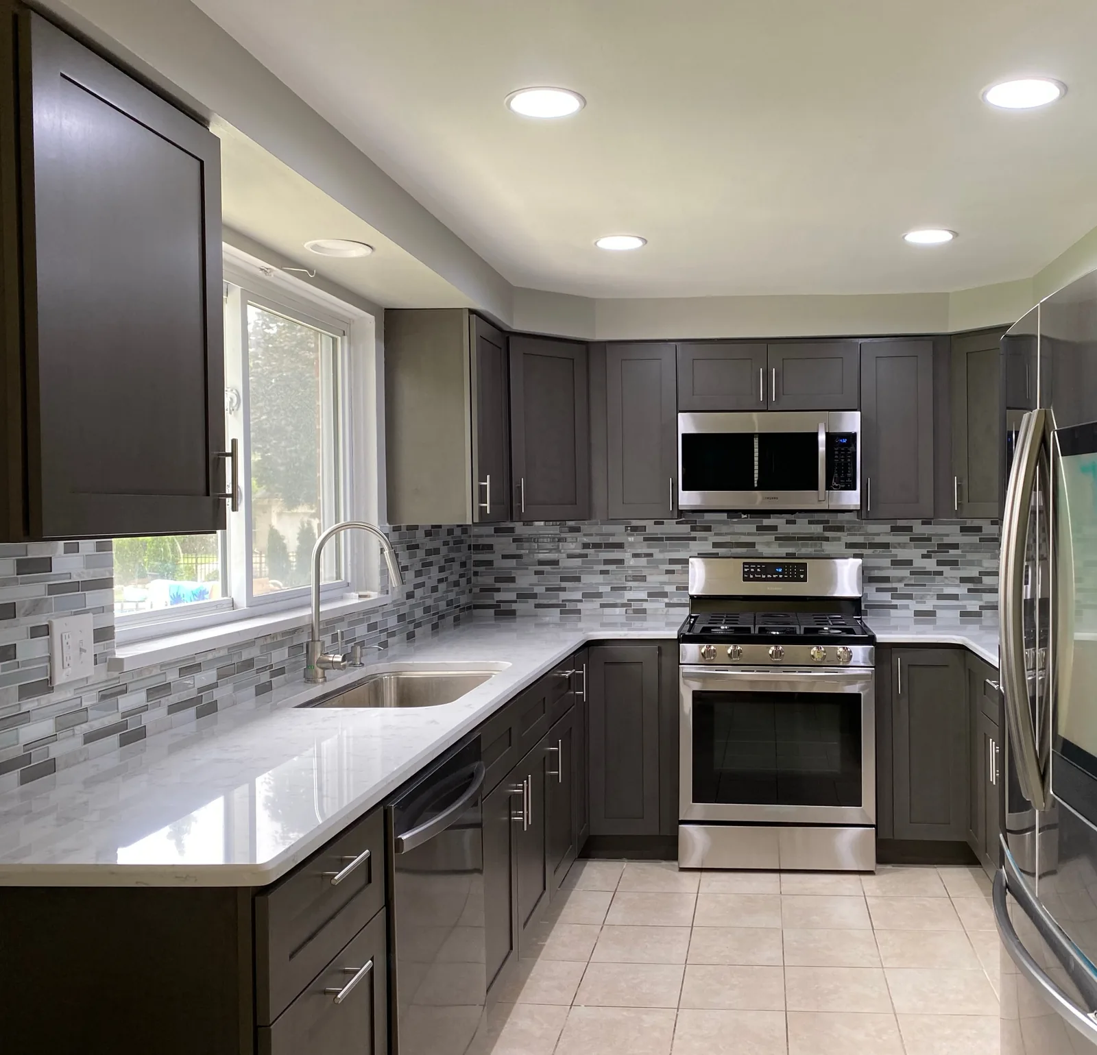 Cleaned kitchen with gray cabinets, tile floor and stainless range — Verde Luxe Cleaning