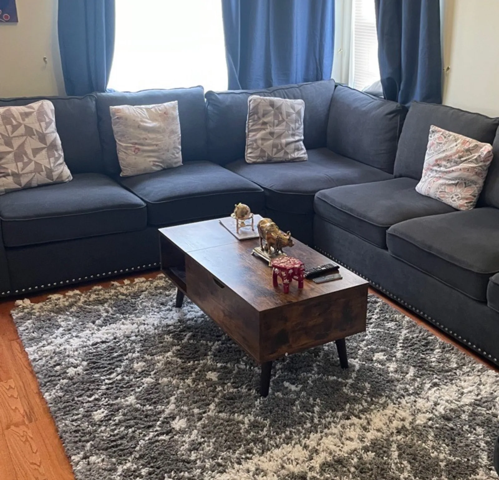 Freshly cleaned living room with sectional sofa and area rug — Verde Luxe Cleaning